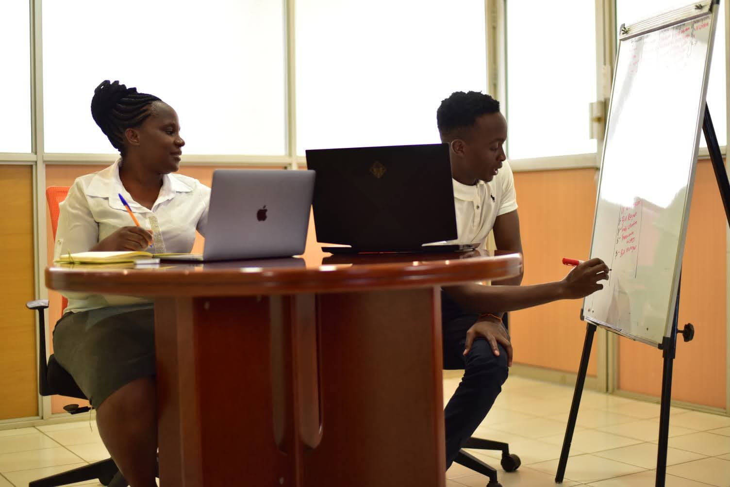 two Gnovation staff members having a brainstroming session in the boardroom