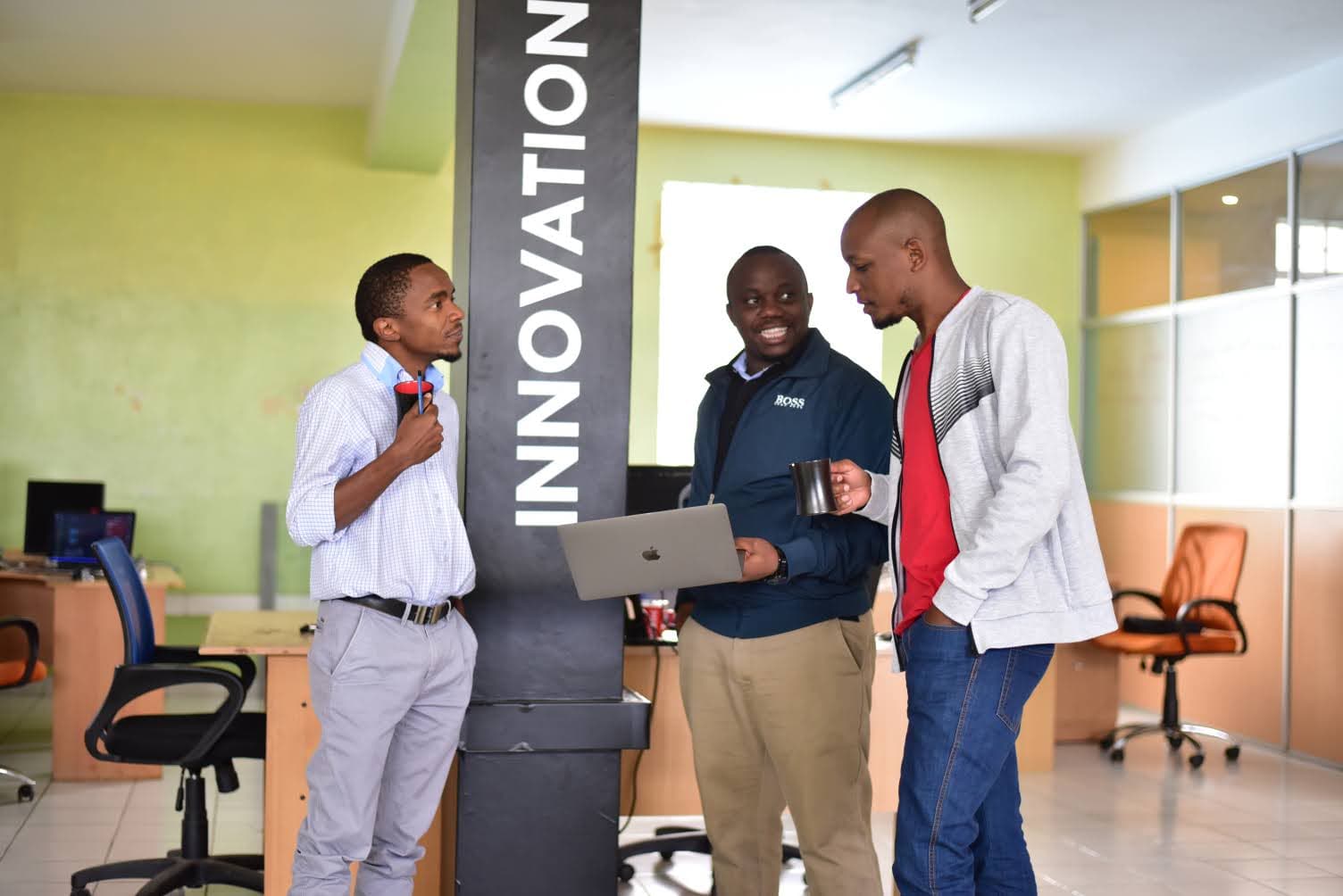 three Gnovation staff members standing and chatting during coffee break 